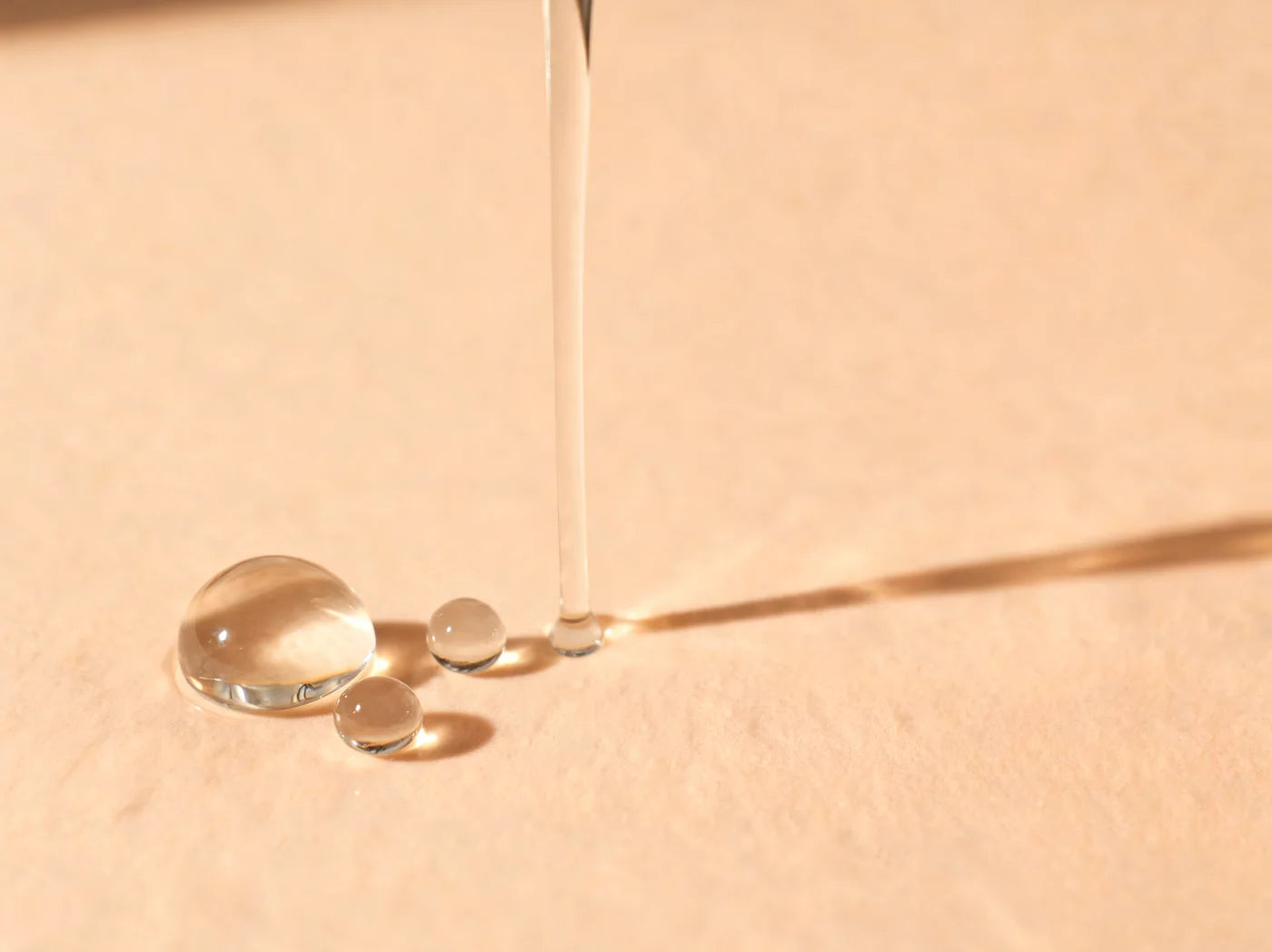 Clear glycerin pouring into a glassy droplet